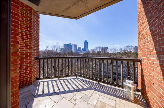Balcony view of city skyline from a building with red brick exterior.