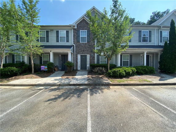 Front view of a two-story townhouse with stone and siding exterior.