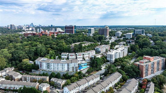 Panoramic view of a cityscape with multiple buildings and lush green areas.