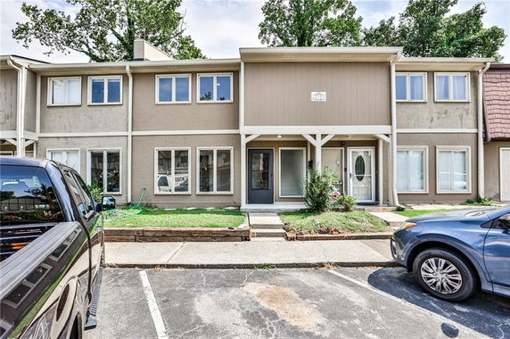 Front view of a two-story townhouse with parking area.