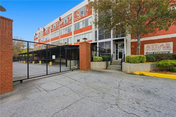 Front view of a multi-story commercial building with signage and a gated entrance.