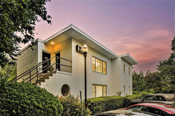 Front view of a modern two-story house with a staircase entrance.