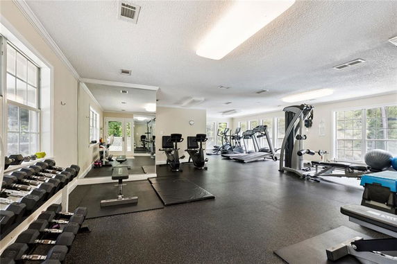 Interior view of a gym area with various fitness equipment, including treadmills and weights.
