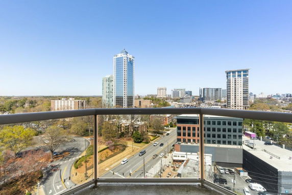 Panoramic view of city buildings and streets seen from a high balcony.