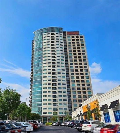 Front view of a high-rise building with multiple floors and large glass windows.