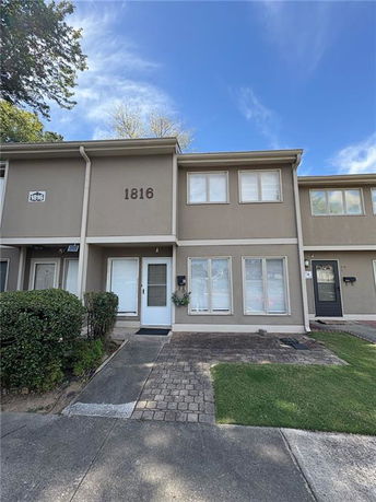 Front view of a two-story townhouse with beige exterior and white framed windows.