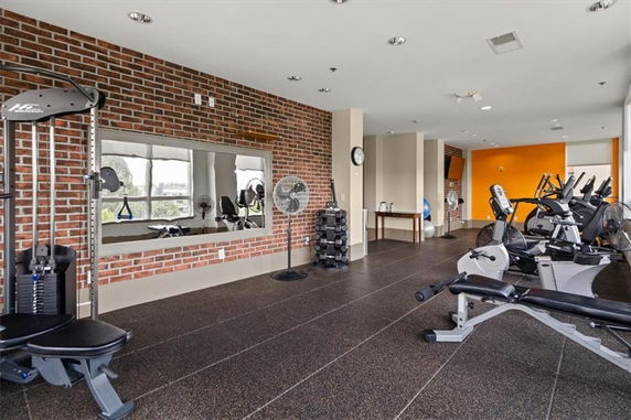 Indoor gym area with exercise equipment and brick walls.