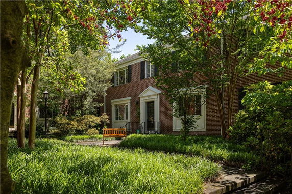 Front view of a two-story brick house with white trim.