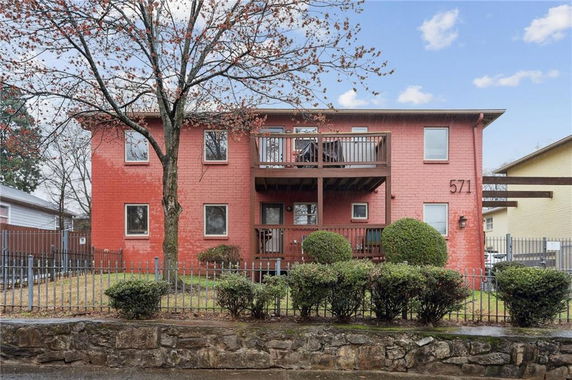 Front view of a two-story red brick building with balconies.