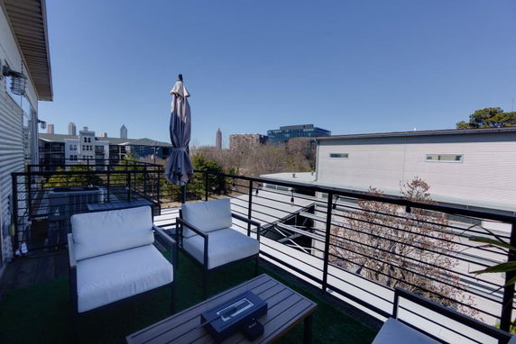 Panoramic balcony view overlooking modern apartment buildings and the city skyline.