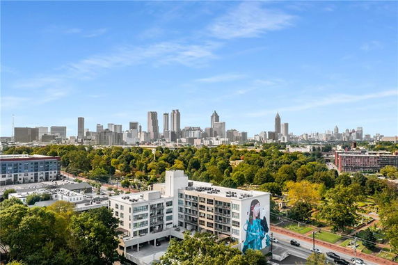 Panoramic view of a city skyline with various buildings and a mural on a nearby building.