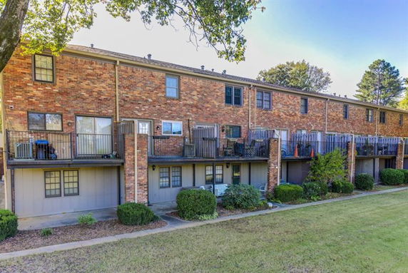 Rear view of a multi-story townhouse with balconies.