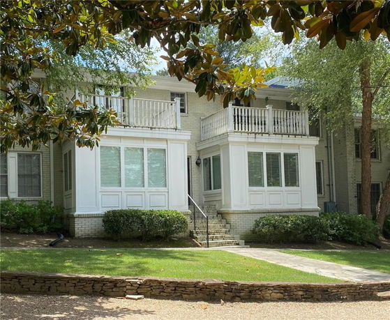 Front view of a two-story house with balconies and large windows.