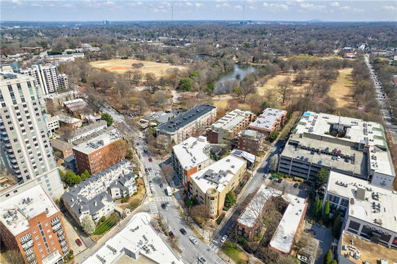 Aerial panoramic view of an urban area with multiple buildings and a park in the background.
