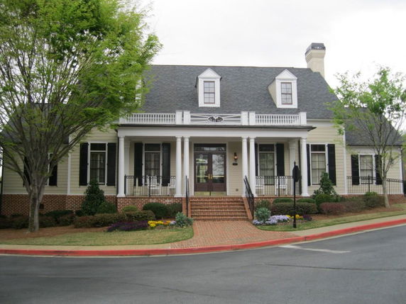 Front view of a house with columns and multiple dormer windows.