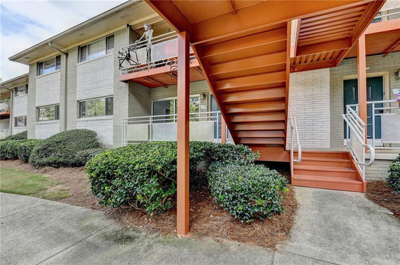 Front view of a two-story apartment building with exterior stairs.