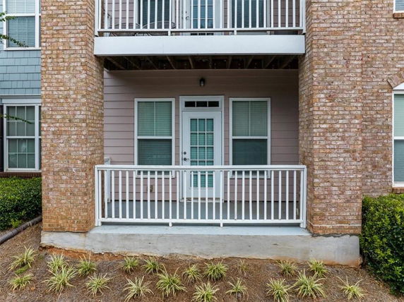 Front view of a building with a brick facade and balcony.