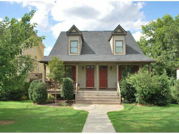 Front view of a house with a porch and two dormer windows.