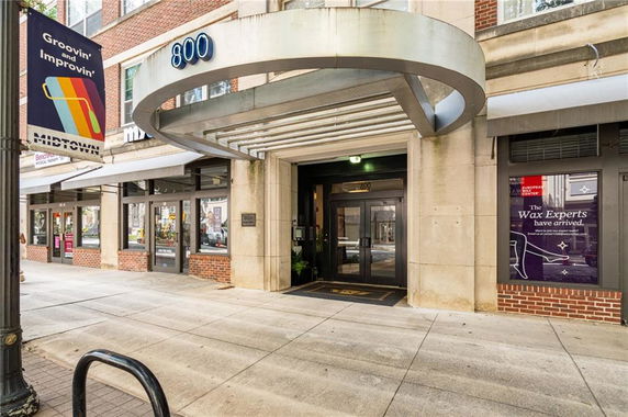 Front view of a building entrance with a modern canopy and glass doors.