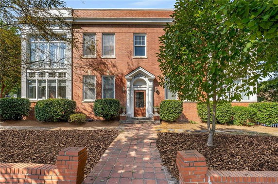 Front view of a two-story brick house with a white columned entrance.