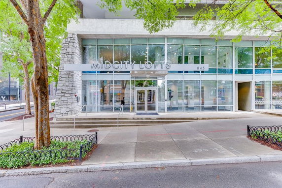 Front view of a modern multi-story building with glass facade labeled 'MIDCITY LOFTS'.