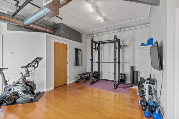 Home gym setup with exercise bike, weight rack, and fitness equipment.
