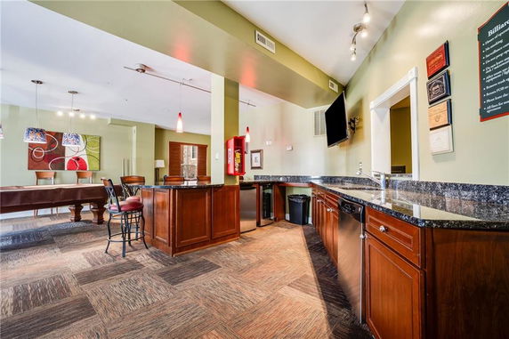 Interior view of a recreational club house with a bar area and billiards table.