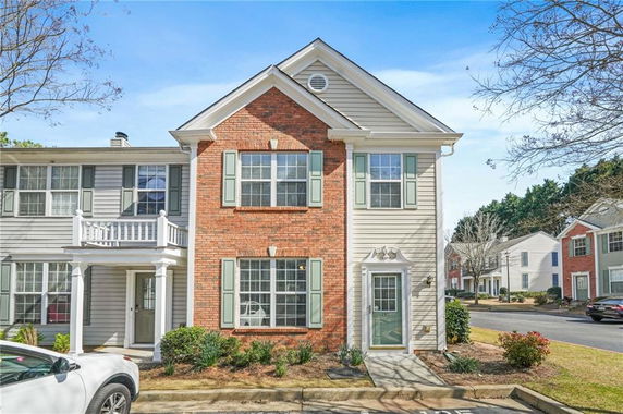 Front view of a two-story townhouse with brick and siding exterior.