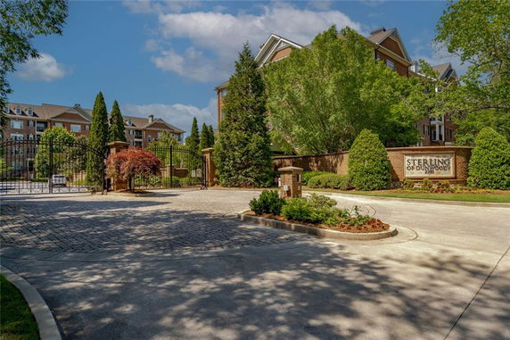 Front view of a gated residential complex with multi-story buildings.