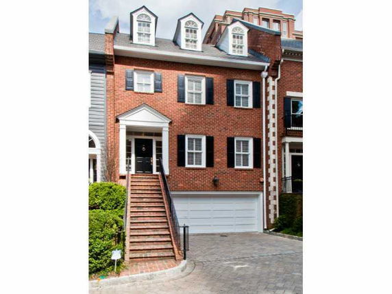 Front view of a three-story brick house with a double garage.