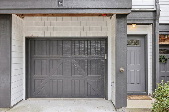 Front view of a house with a gray garage door and entrance door.