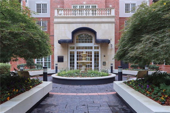 Front view of a multi-story building with a central entrance and landscaped courtyard.