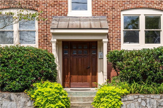 Front view of a brick house with a wooden door.