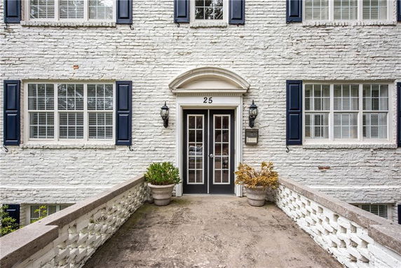 Front view of a brick building entrance with double doors.