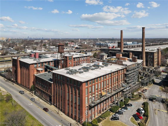 Front view of a large industrial building with multiple stories and tall chimneys.