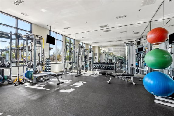 Indoor gym area with exercise equipment and mirrored wall.