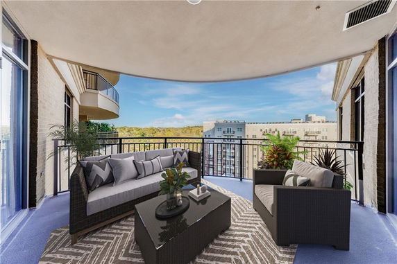 Balcony view with outdoor seating and buildings in the background.