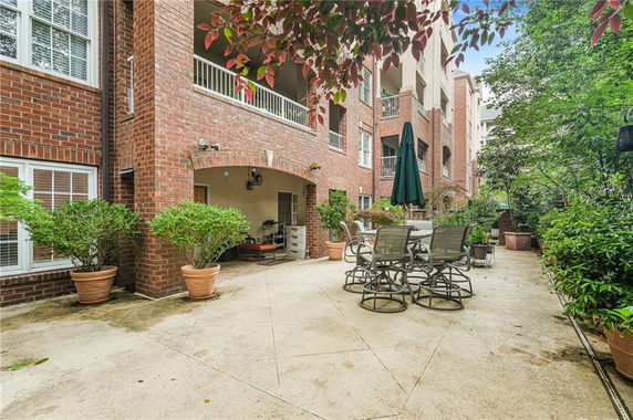 Outdoor patio area with brick building view and outdoor furniture.