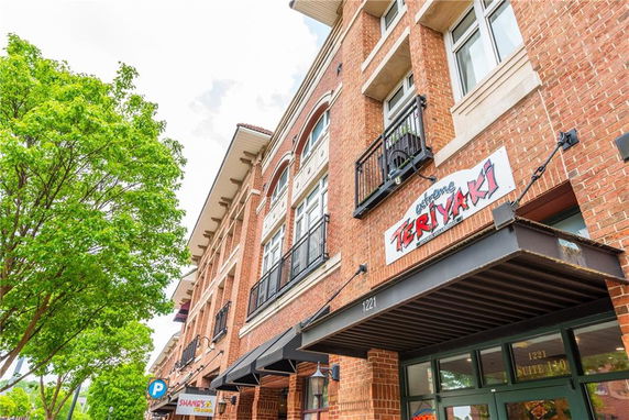 Front view of a multi-story brick building with a restaurant sign.
