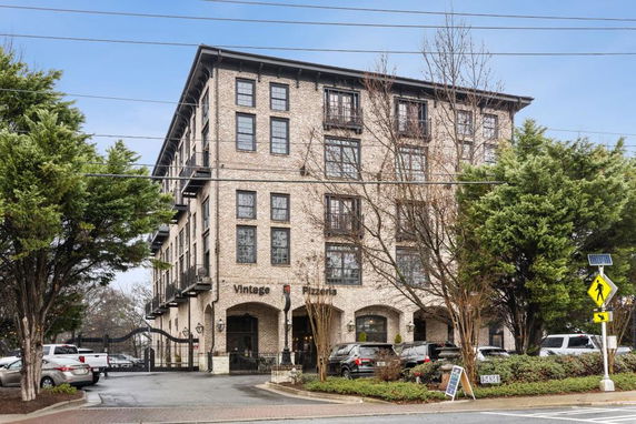 Front view of a multi-story building with a pizzeria on the ground floor.