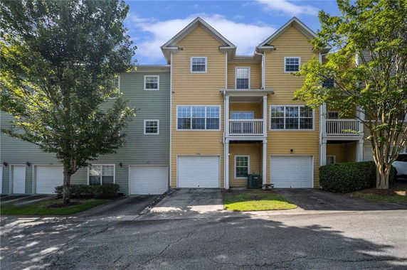 Front view of a townhouse with three stories and multiple garages.