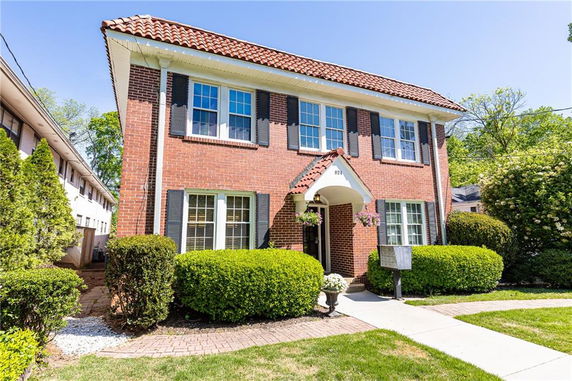 Front view of a two-story brick house with a tiled roof.