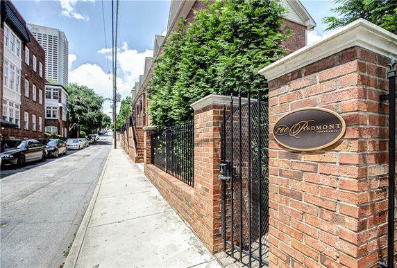 Front view of a brick building with a gate and a sign for 700 Piedmont.