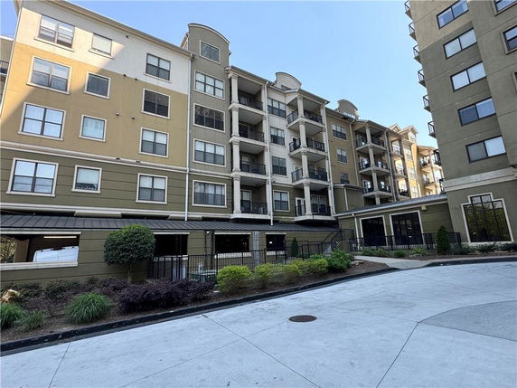Front view of a multi-story apartment building with balconies.