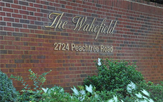Brick wall with the name and address of a building.