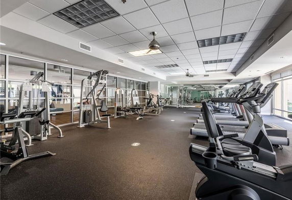 Gym area with various exercise equipment and mirrored walls