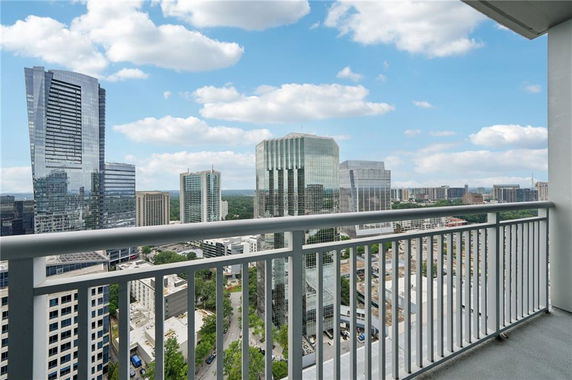 Panoramic view from a balcony overlooking a city skyline with multiple tall buildings.
