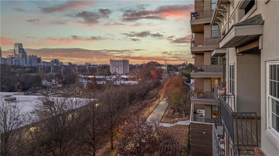 Panoramic view from a high-rise building with cityscape and sunset sky.