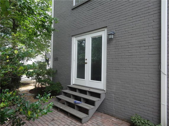 Front view of a house with a brick exterior and French doors.