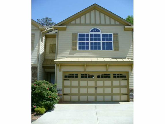 Front view of a house with a double garage and large upper window.
